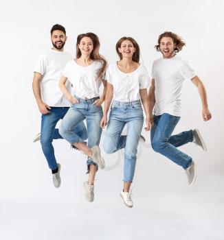 Jumping young people in jeans on white background�