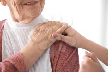 Caregiver with senior woman in nursing home, closeup�