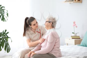 Doctor examining senior woman in nursing home�