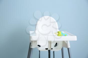 Baby nibbler on high chair against grey background�