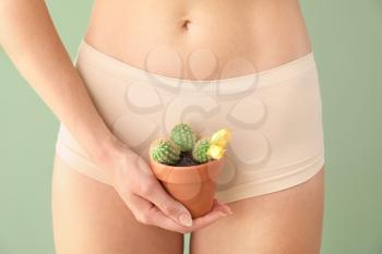 Beautiful young woman with cactus on color background. Depilation concept�