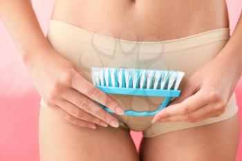 Beautiful young woman with cleaning brush, closeup. Depilation concept�