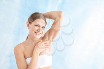 Beautiful young woman after laser hair removal procedure on light background�
