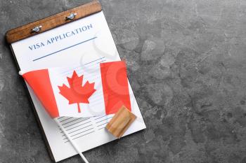 Visa application form, stamp and Canadian flag on table. Concept of immigration�