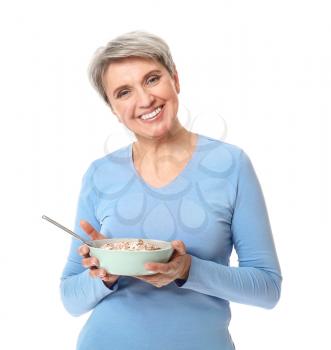 Mature woman with bowl of oatmeal on white background�