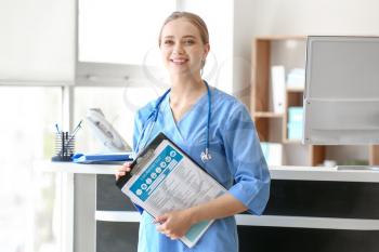 Young medical assistant with results of laboratory tests in clinic�