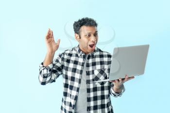 Happy man with laptop on color background�