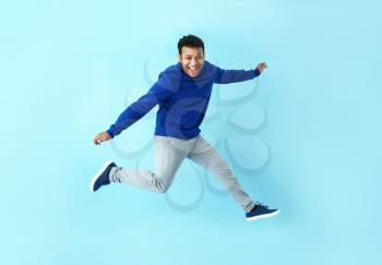 Handsome jumping man on color background�