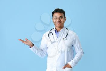 Handsome male doctor on color background�