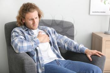 Young man suffering from chest pain at home�
