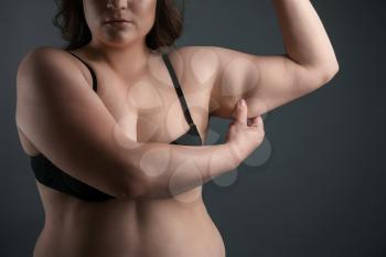 Beautiful plus size woman on grey background. Concept of weight loss�