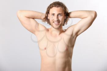 Naked young man after epilation on light background�