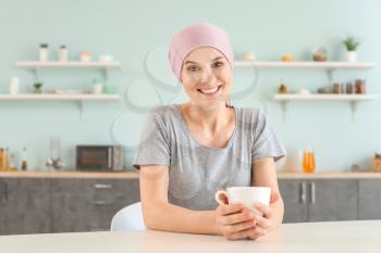 Woman after chemotherapy in kitchen at home�