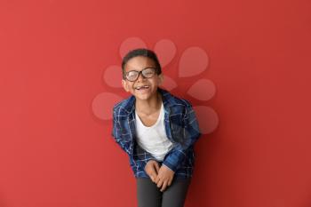Laughing African-American boy on color background�