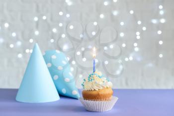 Tasty Birthday cupcake on color table�