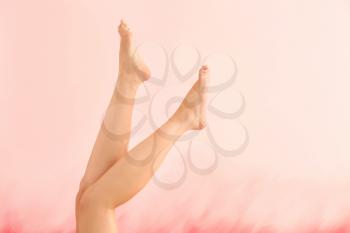 Legs of beautiful young woman after depilation on color background�