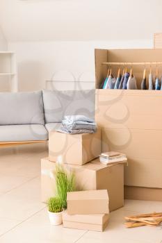 Wardrobe boxes with clothes and other things prepared for house moving in room�