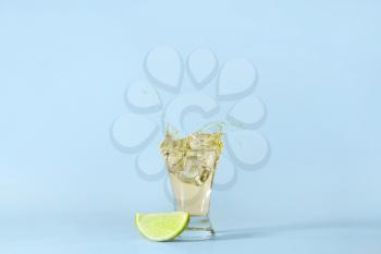 Shot of tequila with splash on light background�