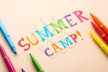 Felt-tip pens and text SUMMER CAMP on color background�
