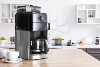 Modern coffee machine on kitchen table�