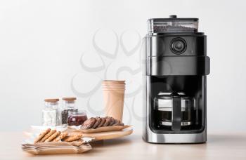Modern coffee machine and sweets on kitchen table�