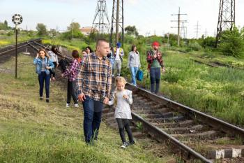 Group of illegal migrants walking along railway tracks�