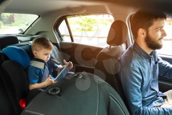 Man driving car with his son buckled in baby seat�