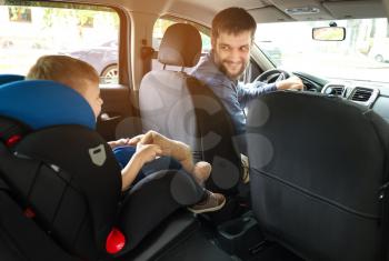 Man driving car with his son buckled in baby seat�