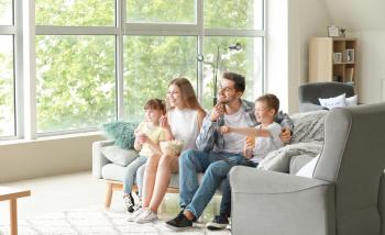 Happy family watching TV at home�