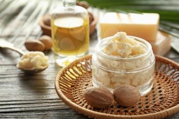 Jar with shea butter on wooden background�