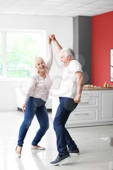 Happy mature couple dancing at home�
