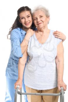 Young caregiver with senior woman on white background�