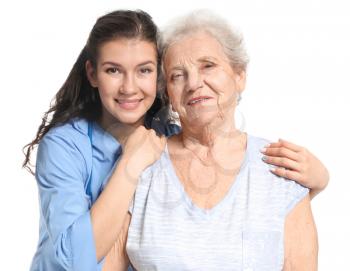 Young caregiver with senior woman on white background�