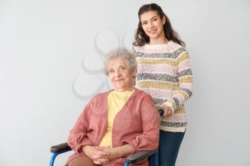Happy woman with grandmother on grey background�