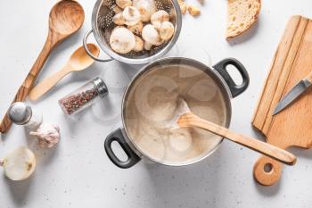 Pot with delicious mushroom cream soup on white table�