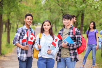 Group of students with Canadian flags outdoors�