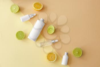 Bottles of shampoo, cosmetics and citrus fruits on color background�