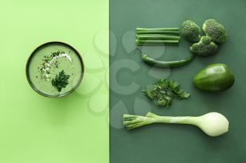Bowl of tasty cream soup and ingredients on color background�