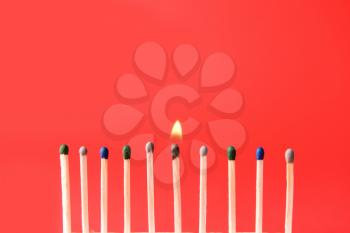 One burning match among non-burning ones on color background. Concept of uniqueness�