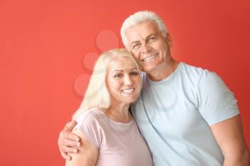 Portrait of happy mature couple on color background�