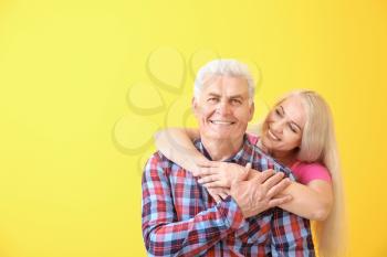 Portrait of happy mature couple on color background�