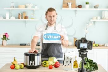 Food blogger announcing prize drawing while recording video in kitchen�