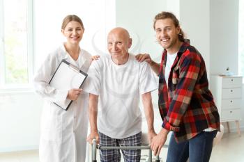 Young man visiting his elderly father in modern clinic�