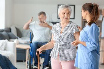 Elderly woman with caregiver in nursing home�