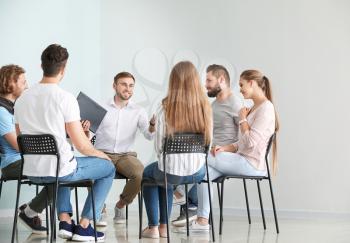 Young people with psychologist at group therapy session�