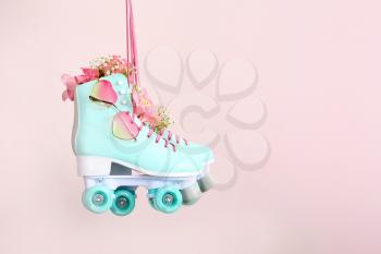 Vintage roller skates with flowers and sunglasses on light background�