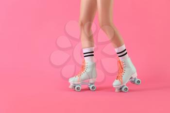Legs of woman in roller skates on color background�