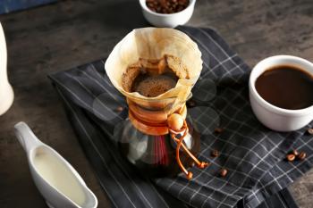 Tasty coffee in chemex on dark table�