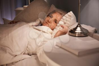 Senior woman suffering from insomnia at night�