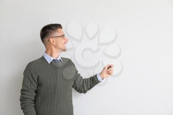 Handsome male teacher with pointer on white background�